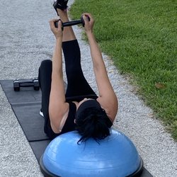 Outdoor training with client working lower Abdominal muscles using Bosu Ball and Dumbbells