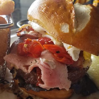 Topgolf - THE PIGGYBACK* 13.5 -Crispy porchetta + cheddar cheese sauce + pickled peppers + lettuce + pretzel bun - Golf Near Me - Roseville, California Topgolf - THE PIGGYBACK* 13.5 -Crispy porchetta + cheddar cheese sauce + pickled peppers + lettuce + pretzel bun - Golf Near Me - Roseville, California