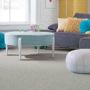 Flooring Liquidator - a living room with a gray couch and a blue ottoman - Flooring Near Me - Orem, Utah