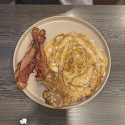 Braves Pancakes House & Restaurant - Cinnamon roll, pancake with a side order of bacon.