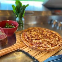 Magdalenes Pizza - Bbq chicken pizza- red sauce, mozzarella, honey chicken, bacon, caramelized onions, roasted red peppers, and our homemade guava BBQ sauce.