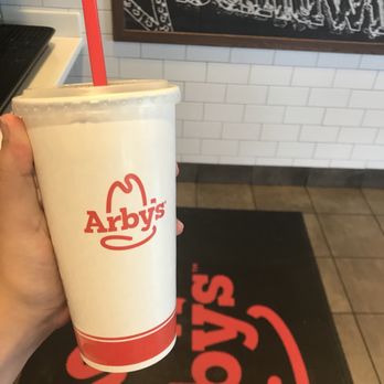 Arby's - a person holding a cup of soda - Fast Food Near Me - Brooksville, Florida