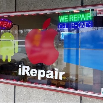 Chico iRepair - iRepair Front window. - The window features neon signs for cell phone repair, including iPhone and Android services, with logos and a WiFi indicator. - Mobile Phone Repair Near Me - Chico, California