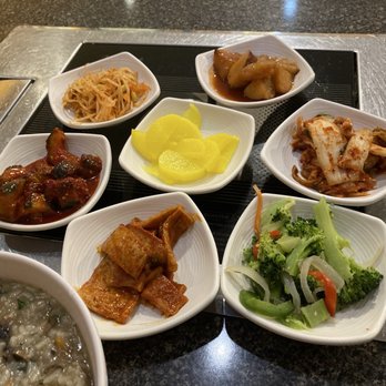 Manna Korean Restaurant - One possible combination of banchan. Veggie congee in corner. - Korean Near Me - Austin, Texas Manna Korean Restaurant - One possible combination of banchan. Veggie congee in corner. - Korean Near Me - Austin, Texas
