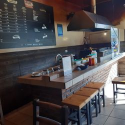 Grill & Burger - Entrada, asador y cocina, justo en la entrada el asador recibe a los clientes.