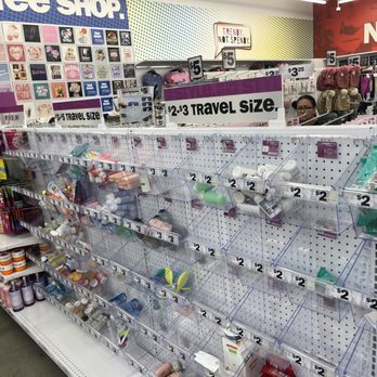 Five Below - Travel sizes - The image shows a retail display at Five Below, featuring various travel-sized toiletries and accessories organized in clear plastic bins. Price tags indicate items are priced at $2 or $3, with signs specifying travel size options. The background includes signage for new and trending items, and a few customers are visible browsing the store. - Toy Stores Near Me - Long Beach, California