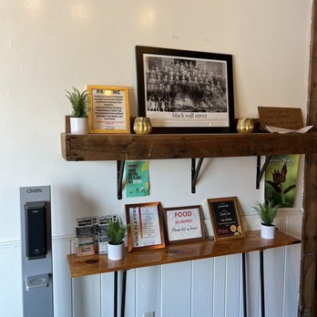 At Eleven Wings & Cuisines - a shelf with framed photos and framed photographs - Soul Food Near Me - Buffalo, New York