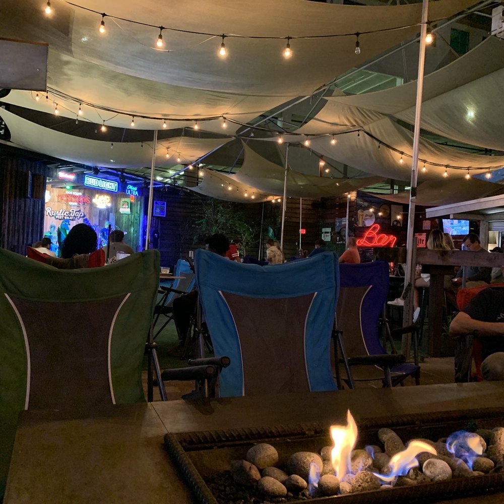 Rustic Tap - people sitting around a fire pit - Cocktail Bars Near Me - Austin, Texas