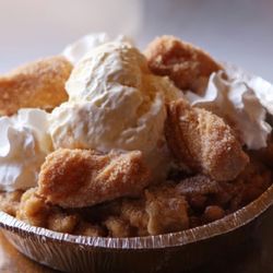 Fairgroundz - Churro Funnel Cake is dusted in cinnamon sugar and topped with a scoop of ice cream and mini  churros bites.