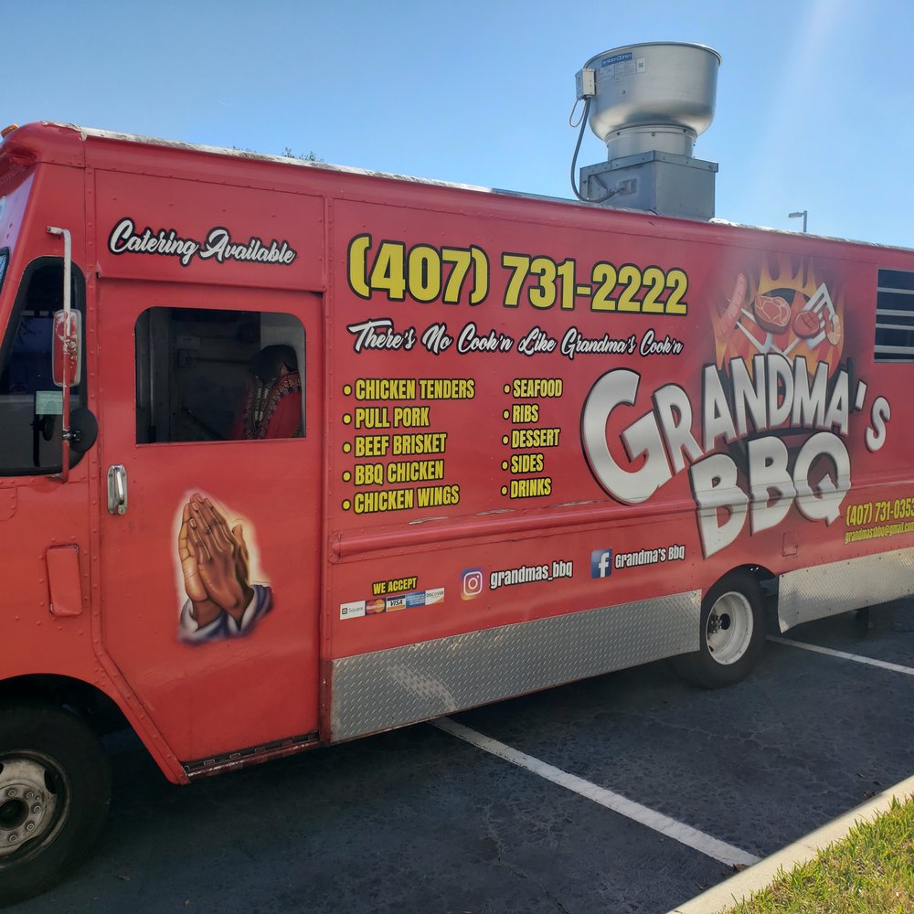 a red food truck parked in a parking lot a red food truck parked in a parking lot