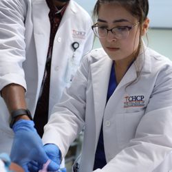The College of Health Care Professions - Medical Assistant student learning how to draw blood and comfort the patient through the procedure.