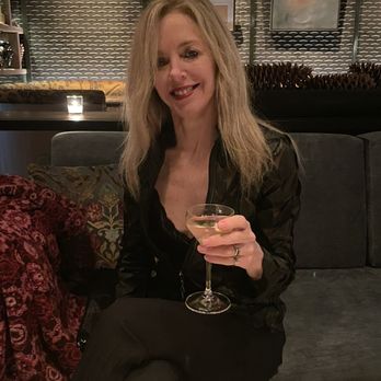 Spygold - a woman sitting on a couch holding a glass of wine - Cocktail Bars Near Me - New York, New York Spygold - a woman sitting on a couch holding a glass of wine - Cocktail Bars Near Me - New York, New York