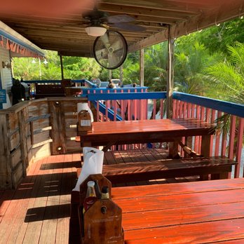 Lazy Flamingo - a wooden deck with tables and a clock - Seafood Near Me - Bokeelia, Florida Lazy Flamingo - a wooden deck with tables and a clock - Seafood Near Me - Bokeelia, Florida