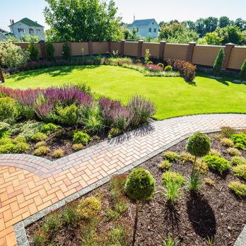 ProLawn Landscaping - a landscaped backyard with a brick walkway - Landscaping Near Me ProLawn Landscaping - a landscaped backyard with a brick walkway - Landscaping Near Me