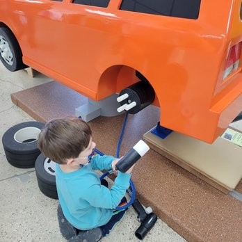 Explore Children's Museum - Changing the tire on a car at Explore Children's Museum - Children's Museums Near Me - Sun Prairie, Wisconsin
