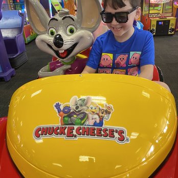 Chuck E. Cheese - a young boy sitting in a toy car - Pizza Near Me - Parkville, Maryland Chuck E. Cheese - a young boy sitting in a toy car - Pizza Near Me - Parkville, Maryland