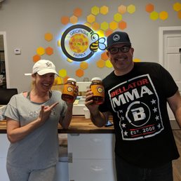 a man and a woman holding two jars of honey a man and a woman holding two jars of honey