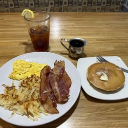 Two egg breakfast with bacon and hash browns and side of pancakes (real butter too!)