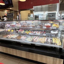 Refrigerated display case with cakes and other desserts.