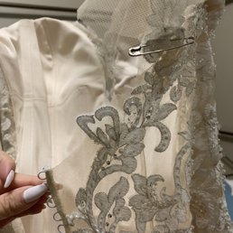 Appliqué added to a backless dress over mesh that could not be removed. Altering the original design and desire of designer gown