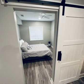 Striker Remodeling - a bedroom with a sliding door - General Contractors Near Me Striker Remodeling - a bedroom with a sliding door - General Contractors Near Me