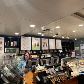 Starbucks - a woman standing in front of a counter - Coffee & Tea Near Me - Hayward, California