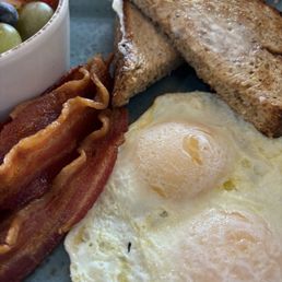 Over easy eggs, million dollar bacon, toast and fruit cup.
