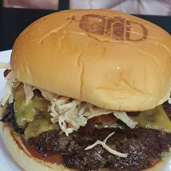 Emoji Burger - Closer view of OMG burger; check the branding g on the bread on top. - Burgers Near Me - Jackson Heights, New York