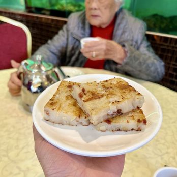 Hong Kong Palace - P/F Turnip Cake with Grannie in the background - ig@blacktigereats - Dim Sum Near Me - Millbrae, California Hong Kong Palace - P/F Turnip Cake with Grannie in the background - ig@blacktigereats - Dim Sum Near Me - Millbrae, California