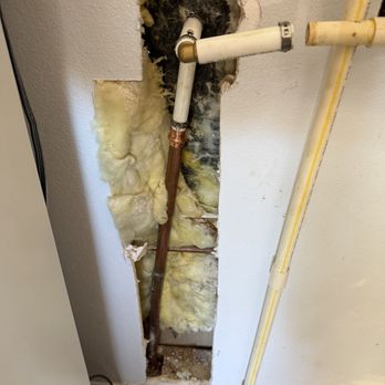 Mac 5 Services - Pex pipe abd fitting replacement.  10$ in fittings at Lowe's!   600$ for this and I get the pleasure of repairing the drywall.   Robbery!!! - A vertical section of wall shows exposed pipes, insulation, and drywall, indicating plumbing work or repair in progress. - Plumbing Near Me - Rockledge, Florida