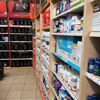 GNC - a pharmacy store aisle with shelves full of medicines - Health Markets Near Me - Lakeland, Florida