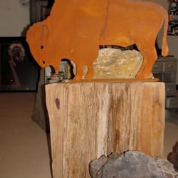 The Copper Gecko - rusted metal bison on tree stump