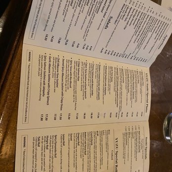 Yuzu Sushi - Menu - The image shows a printed menu from Yuzu Sushi, a Japanese restaurant in Chamblee, GA. The menu includes sections for salads, sushi, and special rolls, with detailed descriptions and prices. It features items such as cucumber salad, seaweed salad, various sashimi, and specialty rolls like the Yuzu Special Rolls. The menu also contains warnings about raw seafood and emphasizes the use of fresh ingredients. The menu is laid out in a clear, organized format with multiple sections and pricing information. - Japanese Near Me - Chamblee, Georgia