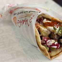 Lamb and Beef gyro with white sauce(similar to tzatziki), green chili chutney and their red chili hot sauce