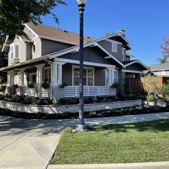 Midpoint Construction - Retaining wall and pillars stripped of original fake rock. Changed to travertine and expanded wall around front of house - General Contractors Near Me