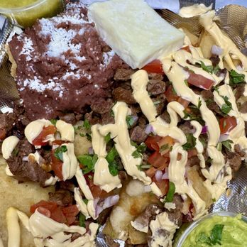 Tolis Pupuseria - Nachos Salvadoreños: handmade fried tortilla crisps topped with grilled steak, refried beans, fresh cheese, crema, pico de gallo & avocado. - Salvadoran Near Me - Brooklyn Park, Minnesota Tolis Pupuseria - Nachos Salvadoreños: handmade fried tortilla crisps topped with grilled steak, refried beans, fresh cheese, crema, pico de gallo & avocado. - Salvadoran Near Me - Brooklyn Park, Minnesota