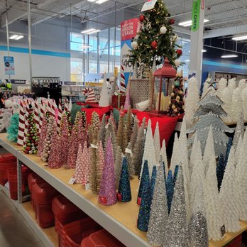 At Home - I do love these trees. Small but a mighty colorful addition to decorating. - A variety of Christmas trees and holiday decorations are arranged on a table inside a retail store, with store signage and shelving visible in the background. - Home Decor Near Me - Albuquerque, New Mexico
