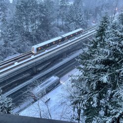 SkyTrain - Some early-am snow yesterday - Skytrain approaching Lougheed Town Centre Stn, bus leaving stop on Lougheed Hwy below.