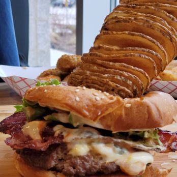 Burger Factory - a large hamburger with fries on a cutting board - Burgers Near Me - Mississauga, Ontario