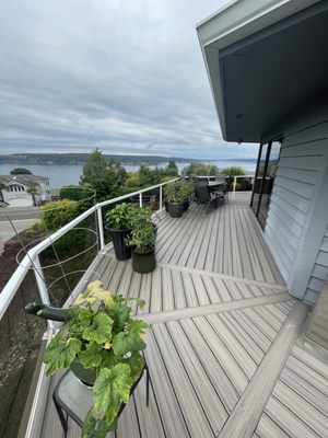 TREX Surrounding Deck Tacoma - TREX Wraparound Deck with RainEscape System – Tacoma, WA | Moses Field Remodeling & Design
This custom wraparound deck in Tacoma offers the ultimate combination of durability, style, and year-round functionality — thanks to a premium TREX decking system paired with a fully integrated Trex RainEscape water management system beneath the surface.
With sweeping views of the Puget Sound, the homeowners wanted a deck that made the most of their outdoor living potential — without constant maintenance or weather concerns. We designed and built a completely new deck structure using high-performance composite decking, giving the look of natural wood with the low-maintenance benefits of TREX.
Underneath, we installed the Trex RainEscape System, a concealed drainage solution that captures water and channels it away from the framing. This protects the substructure from rot and creates dry, usable space below the deck — ideal for storage, entertaining, or future expansion. The detail shots show the full installation process, including joist prep and drainage routing, all built to spec and fully code-compliant.
The layout wraps around the house, creating multiple zones for entertaining and relaxing, with angled board inlays for visual interest and clean transitions. A modern glass and aluminum railing system keeps views unobstructed while providing safe, secure perimeter protection.
We meticulously framed and flashed all connections, ensuring water can’t penetrate the structure over time. From the joists to the finish trim, this deck was built to withstand the Pacific Northwest climate while looking amazing from every angle.
Now complete, this deck adds tremendous square footage of usable outdoor space with unobstructed views, durable materials, and protected substructure. It’s a showcase of smart design and quality execution — a long-term investment in comfort, beauty, and performance.
If you’re planning a composite deck project, especially one with multi-levels, rainproofing, or modern rail systems, Moses Field Remodeling & Design delivers precision work that elevates your outdoor living space — and makes it last. TREX Surrounding Deck Tacoma - TREX Wraparound Deck with RainEscape System – Tacoma, WA | Moses Field Remodeling & Design
This custom wraparound deck in Tacoma offers the ultimate combination of durability, style, and year-round functionality — thanks to a premium TREX decking system paired with a fully integrated Trex RainEscape water management system beneath the surface.
With sweeping views of the Puget Sound, the homeowners wanted a deck that made the most of their outdoor living potential — without constant maintenance or weather concerns. We designed and built a completely new deck structure using high-performance composite decking, giving the look of natural wood with the low-maintenance benefits of TREX.
Underneath, we installed the Trex RainEscape System, a concealed drainage solution that captures water and channels it away from the framing. This protects the substructure from rot and creates dry, usable space below the deck — ideal for storage, entertaining, or future expansion. The detail shots show the full installation process, including joist prep and drainage routing, all built to spec and fully code-compliant.
The layout wraps around the house, creating multiple zones for entertaining and relaxing, with angled board inlays for visual interest and clean transitions. A modern glass and aluminum railing system keeps views unobstructed while providing safe, secure perimeter protection.
We meticulously framed and flashed all connections, ensuring water can’t penetrate the structure over time. From the joists to the finish trim, this deck was built to withstand the Pacific Northwest climate while looking amazing from every angle.
Now complete, this deck adds tremendous square footage of usable outdoor space with unobstructed views, durable materials, and protected substructure. It’s a showcase of smart design and quality execution — a long-term investment in comfort, beauty, and performance.
If you’re planning a composite deck project, especially one with multi-levels, rainproofing, or modern rail systems, Moses Field Remodeling & Design delivers precision work that elevates your outdoor living space — and makes it last.