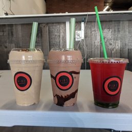 three drinks with straws on a table