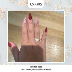 K's Nail - Classy matte burgundy stiletto nails with elegant gold swirl accents. A timeless look with a modern twist. Book today!