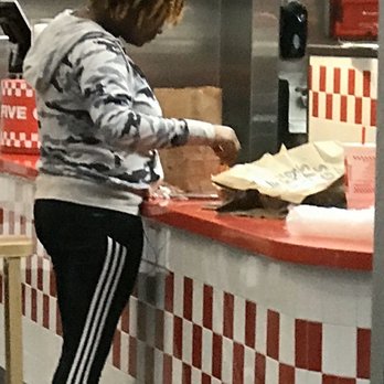 Five Guys - Employee in slippers. Employee dinner and drink where orders are being put together. Bag of fries that employees are eating out of. - Burgers Near Me - New Orleans, Louisiana