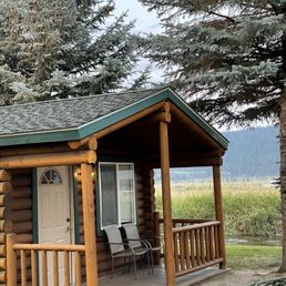 Cabin #5, porch with chairs and a stream behind the cabin Cabin #5, porch with chairs and a stream behind the cabin
