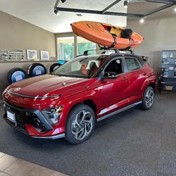 Hyundai of Yakima - Side profile of a Hyundai SUV with a boat strapped to the roof rails