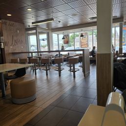 Almost empty restaurant, 3 people sitting near window