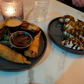 Harry's at Hofheimer - Beef and mac and cheese egg rolls (nearest) and burrata on toast topped with balsamic glaze and peaches (furthest) - New American Near Me - Richmond, Virginia Harry's at Hofheimer - Beef and mac and cheese egg rolls (nearest) and burrata on toast topped with balsamic glaze and peaches (furthest) - New American Near Me - Richmond, Virginia