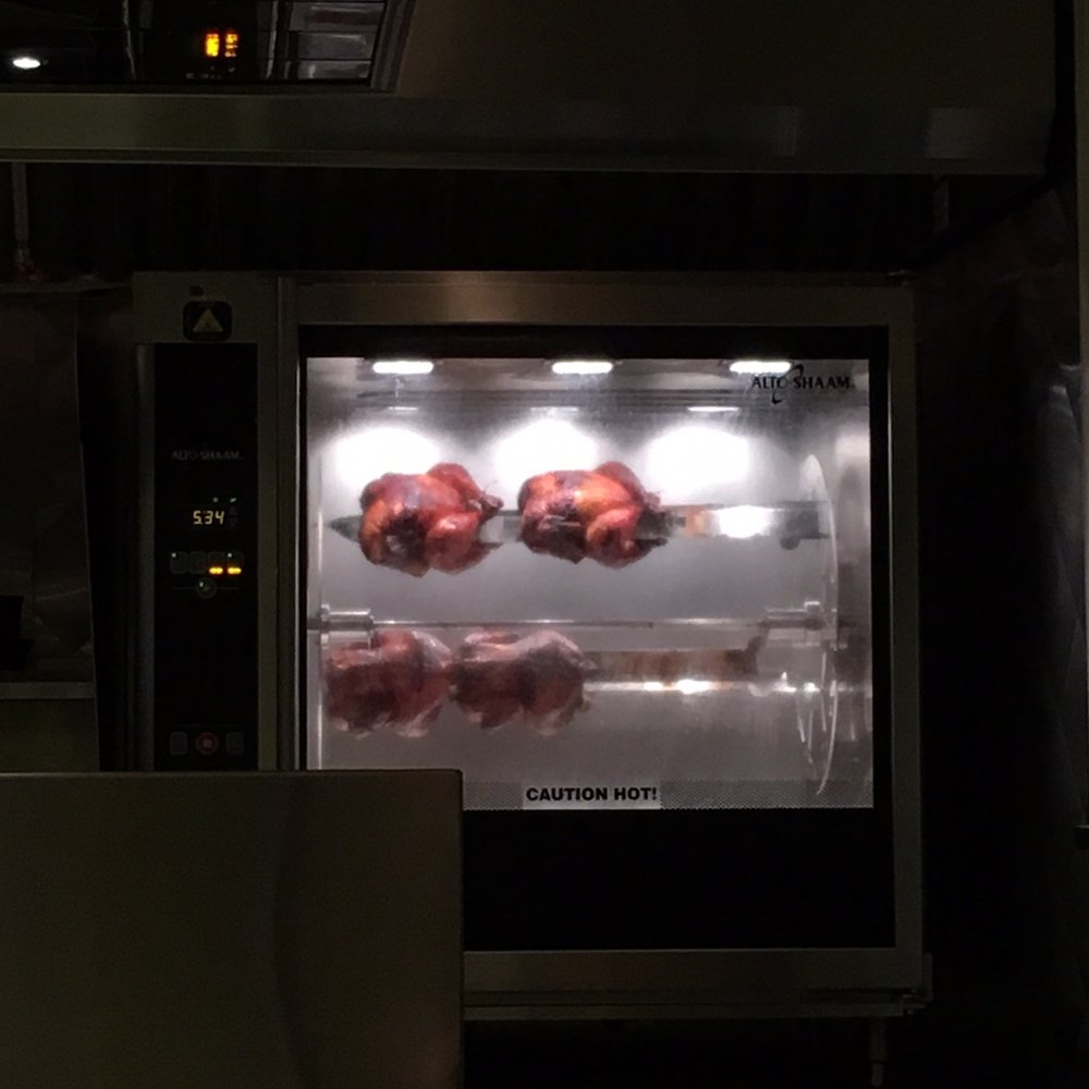 Chez Tousignant - Roasted chickens rolling away inside the oven - Burgers Near Me - Montreal, Quebec