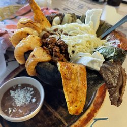 Molcajete...shrimp, beef, chicken, and chorizo..Oaxaca cheese, nopales, onion & chile with a small side of been.