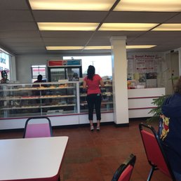 a woman standing in front of a bakery counter a woman standing in front of a bakery counter